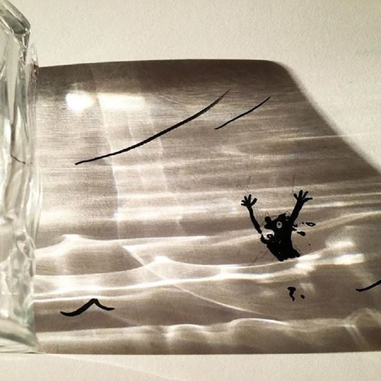Тень от стеклянного стакана превратилась в бушующее море, в котором тонет человек
Фото: @vincent_bal